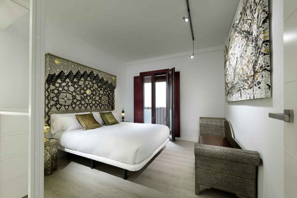 cozy bedroom with balcony overlooking the alhambra of granada, spain