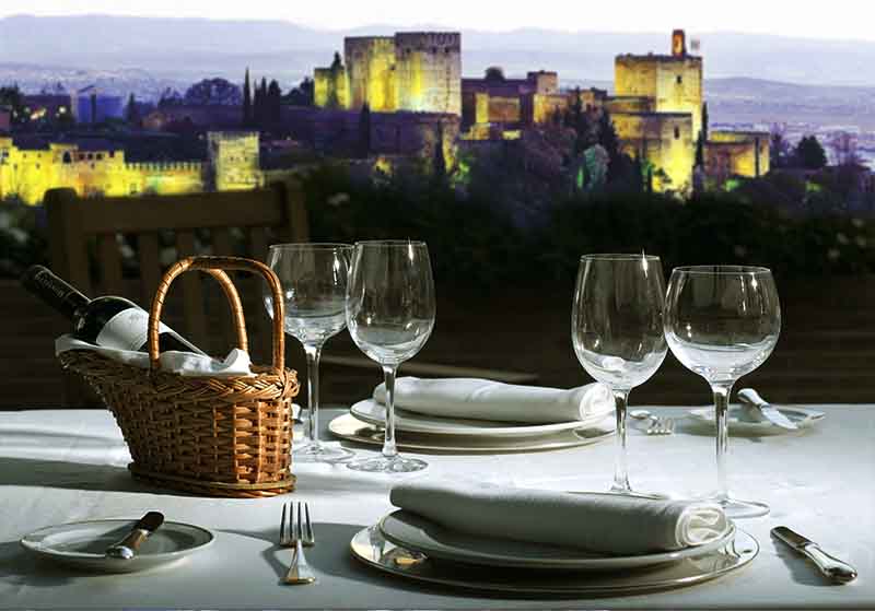 romantic diner table setup overlooking the alhambra at night in albaicin, granada, spain